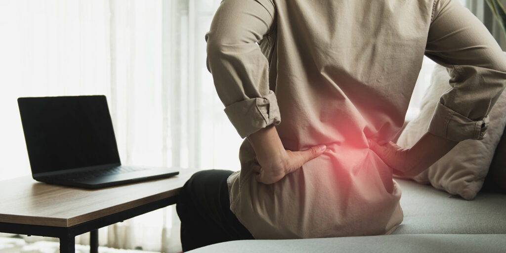 دست روی کمر و لپتاپ روی میز کوچک