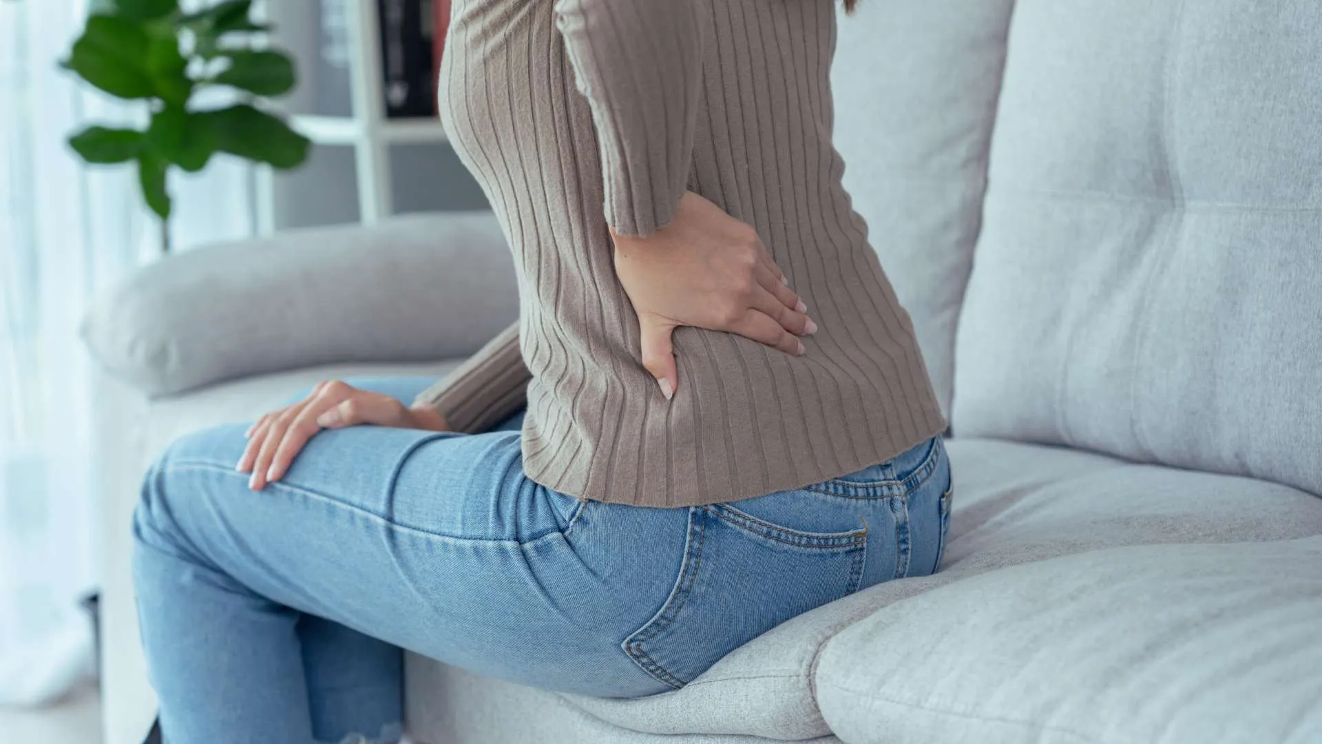 کمردرد زن روی کاناپه